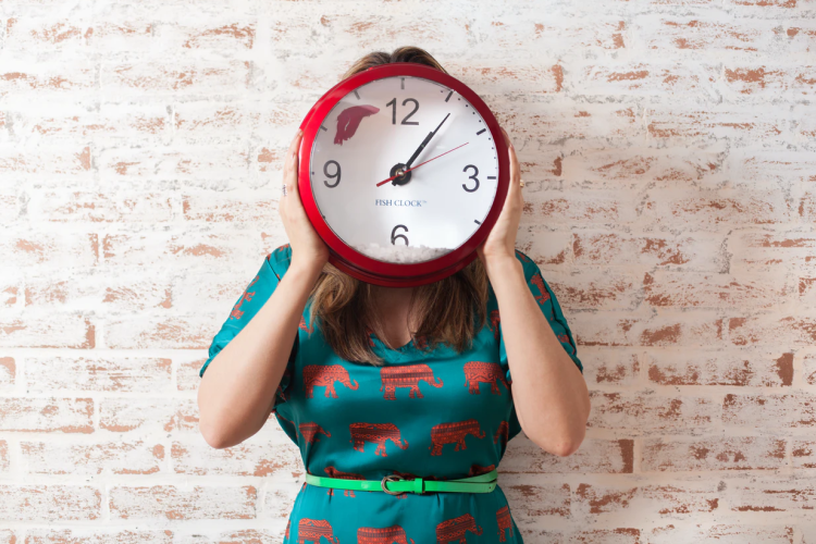 woman covering face with clock