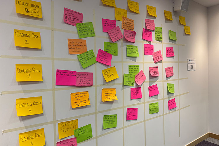 A wall covered with colorful sticky notes arranged in rows and columns.