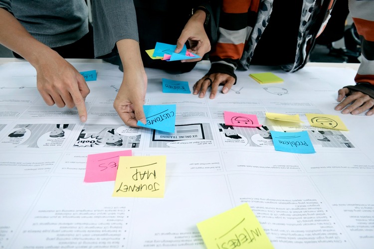 Stock image of people using post-it notes in a user testing session.